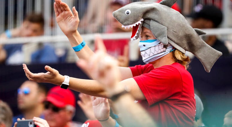 In this Sept. 29, 2019, file photo, a fan wears a shark hat as Washington Nationals' Gerardo Parra comes up to bat in the eighth inning of a baseball game against the Cleveland Indians at Nationals Park in Washington.