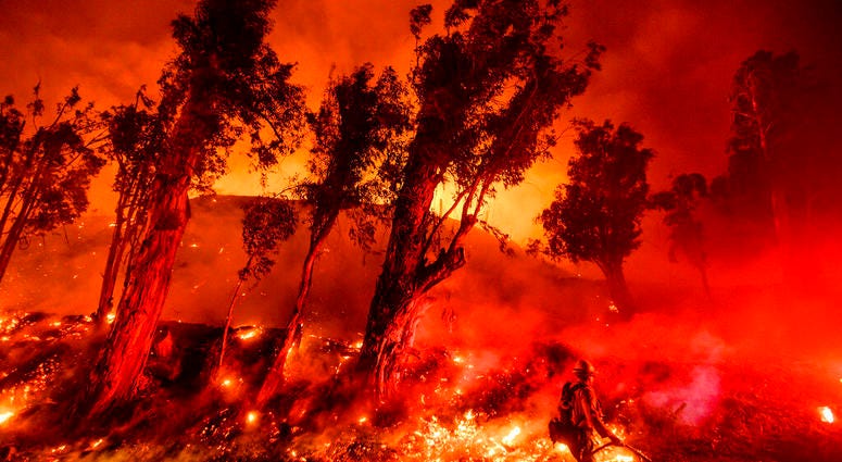 Flames from a backfire consume a hillside as firefighters battle the Maria Fire in Santa Paula, Calif. The decade that just ended was by far the hottest ever measured on Earth, capped off by the second-warmest year on record, NASA and the National Oceanic