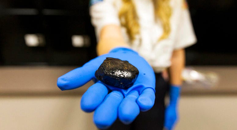 In this Jan. 27, 2016 photo, 39.6-grams of black tar heroin, with a street value of about $12,000, is among many other heroin-related items in Post Falls Police Department's evidence room in Post Falls, Idaho.