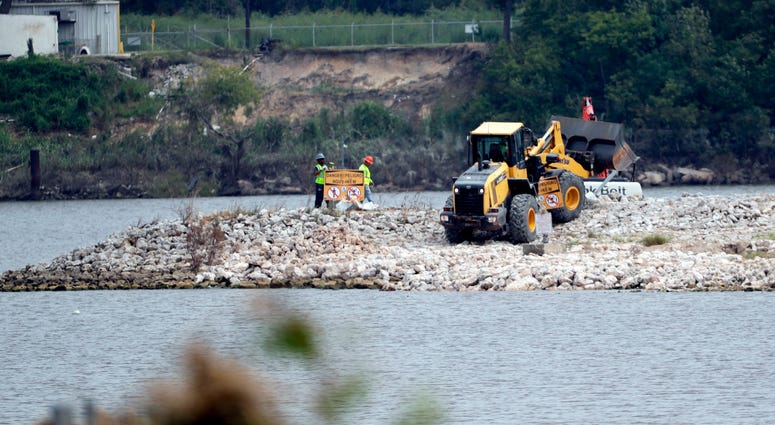San Jacinto River Waste Pits In this Sept. 13, 2017, file photo, workers are shown at San Jacinto River Waste Pits near the Interstate 10 bridge over the river in Channelview, Texas. Federal environmental regulators have reached a long-awaited agreement with the owners of a polluted