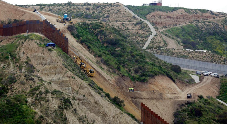 construction crews replace a section of the primary wall separating San Diego, above right, and Tijuana, Mexico, below left, seen from Tijuana, Mexico. construction crews replace a section of the primary wall separating San Diego, above right, and Tijuana, Mexico, below left, seen from Tijuana, Mexico.