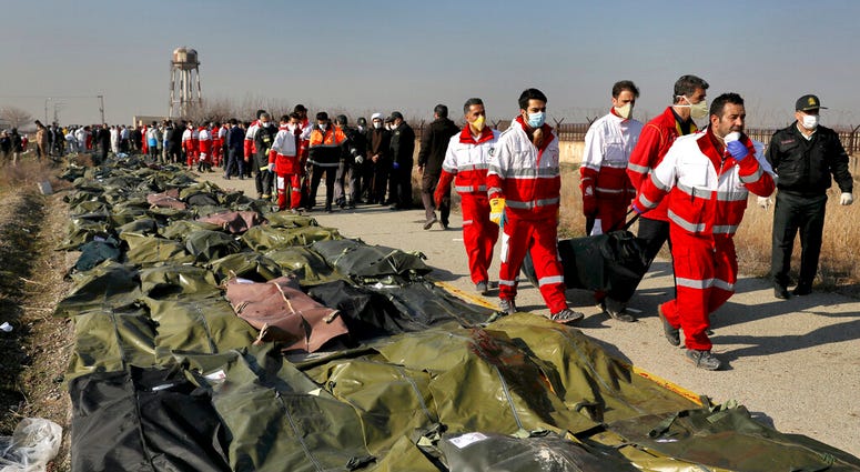 Rescue workers carry the body of a victim of a Ukrainian plane crash in Shahedshahr, southwest of the capital Tehran, Iran Rescue workers carry the body of a victim of a Ukrainian plane crash in Shahedshahr, southwest of the capital Tehran, Iran