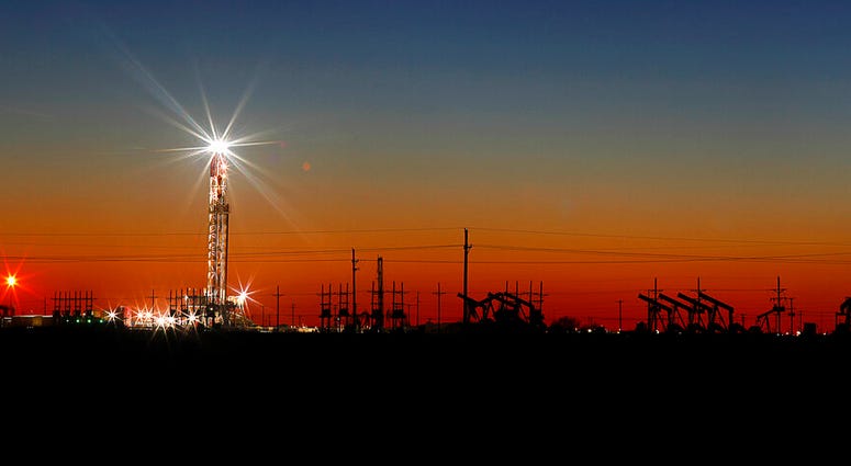 An oil rig lights up the horizon on the outskirts of Midland, Texas after a late sunset. An oil rig lights up the horizon on the outskirts of Midland, Texas after a late sunset.