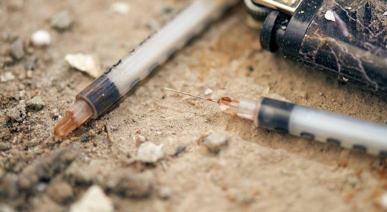 Used syringe on the ground Used syringe on the ground