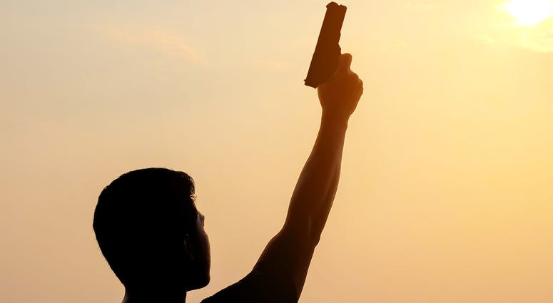 a man lifting a hand holding a gun a man lifting a hand holding a gun