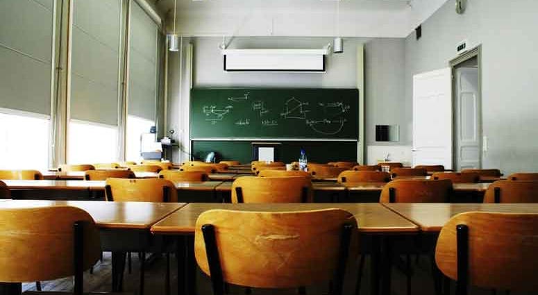 A large, empty classroom with wooden chairs. A large, empty classroom with wooden chairs.