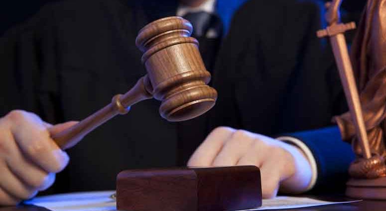 Male judge in a courtroom striking the gavel Male judge in a courtroom striking the gavel