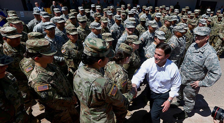 AP-National Guard Arizona's Republican Gov. Doug Ducey, front right, meets with Arizona National Guard soldiers prior to their deployment to the Mexico border at the Papago Park Military Reservation on Monday, April 9, 2018, in Phoenix. Ducey told the group of soldiers pre