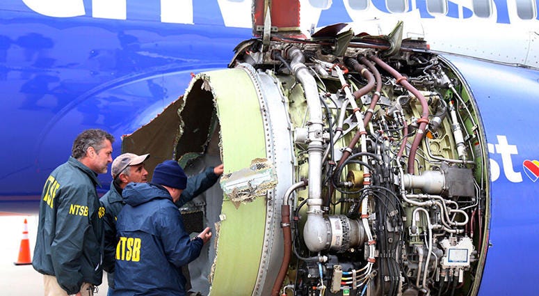 National Transportation Safety Board investigators examine damage to the engine of the Southwest Airlines plane that made an emergency landing at Philadelphia International Airport in Philadelphia on Tuesday, April 17, 2018. The Southwest Airlines jet ble
