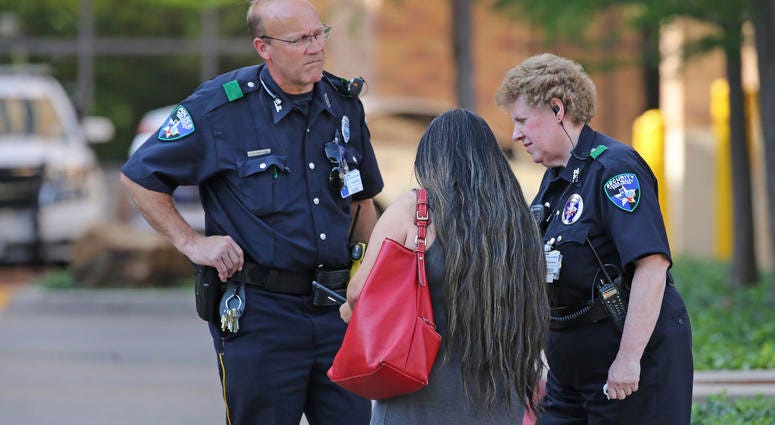 Law enforcement officers stand guard at the driveway entrance to the emergency room at Presbyterian Hospital in Dallas. Law enforcement officers stand guard at the driveway entrance to the emergency room at Presbyterian Hospital in Dallas.