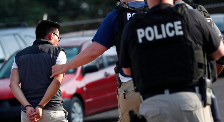 A man is taken into custody at a Koch Foods Inc. plant in Morton, Miss. A man is taken into custody at a Koch Foods Inc. plant in Morton, Miss.