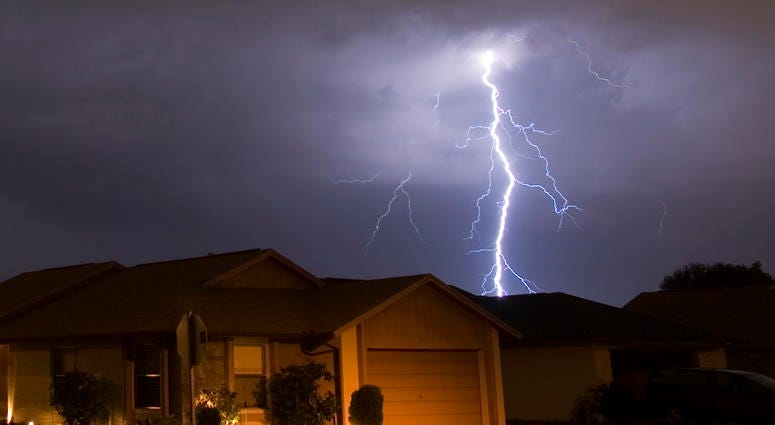 Lightning strikes in the night near family houses Lightning strikes in the night near family houses