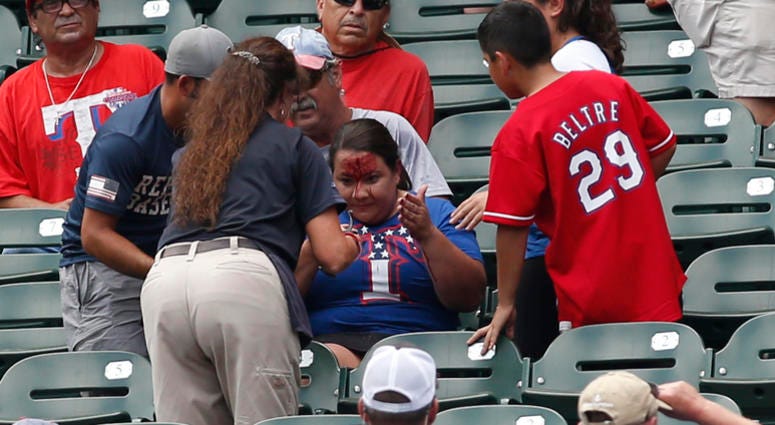 Rangers fans is attended to after being hit in the head with a ball Rangers fans is attended to after being hit in the head with a ball