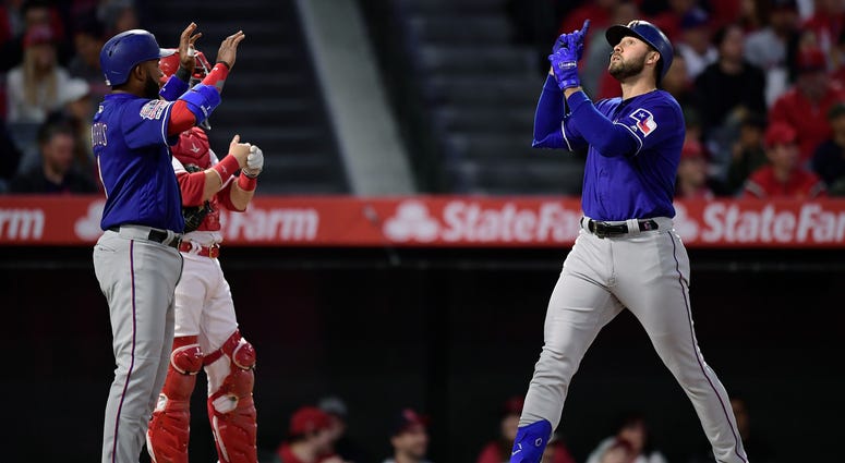 Texas Rangers' Joey Gallo, right, gestures as he scores after hitting a three-run home run as Elvis Andrus, left, waits to congratulate him and Los Angeles Angels catcher Jonathan Lucroy stands at the plate during the first inning of a baseball game Thurs Texas Rangers' Joey Gallo, right, gestures as he scores after hitting a three-run home run as Elvis Andrus, left, waits to congratulate him and Los Angeles Angels catcher Jonathan Lucroy stands at the plate during the first inning of a baseball game Thurs