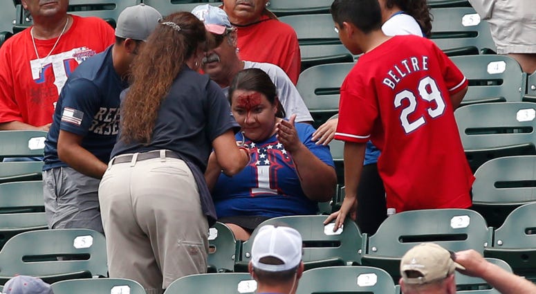 Texas Rangers fans is attended to after being hit in the head with a ball Texas Rangers fans is attended to after being hit in the head with a ball