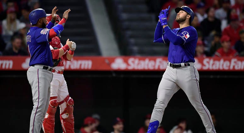 Texas Rangers' Joey Gallo, right, gestures as he scores after hitting a three-run home run as Elvis Andrus, left, waits to congratulate him and Los Angeles Angels catcher Jonathan Lucroy stands at the plate during the first inning of a baseball game Thurs Texas Rangers' Joey Gallo, right, gestures as he scores after hitting a three-run home run as Elvis Andrus, left, waits to congratulate him and Los Angeles Angels catcher Jonathan Lucroy stands at the plate during the first inning of a baseball game Thurs