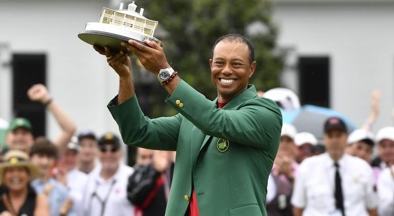 Tiger Woods Tiger Woods celebrates with the green jacket and trophy after winning The Masters golf tournament