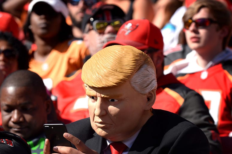 A fan dressed as President Donald Trump keeps his fingers moving on his iPhone during the Carolina Panthers against Tampa Bay Buccaneers game on Sunday, Oct. 29, 2017 at Raymond James Stadium in Tampa, Fla. The Panthers defeated the Buccaneers 17-3. (Phot