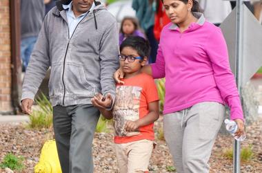 Bharani Rayana, 39, and Madhuri Adari, 32, hold tight to their second-grade son Daksha Rayana 8, following reunification at the Highlands Ranch Recreation Center after a school shooting. Colorado Stem School Shooting