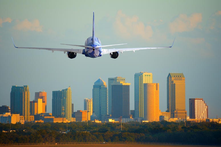 Passenger jet airliner plane arriving or departing Tampa International Airport in Florida at sunset or sunrise