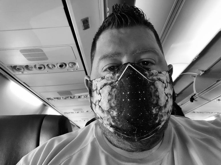 Big Mic flying on a plane with a mask on