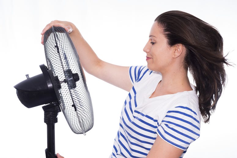 Woman cooling off with a fan Woman cooling off with a fan