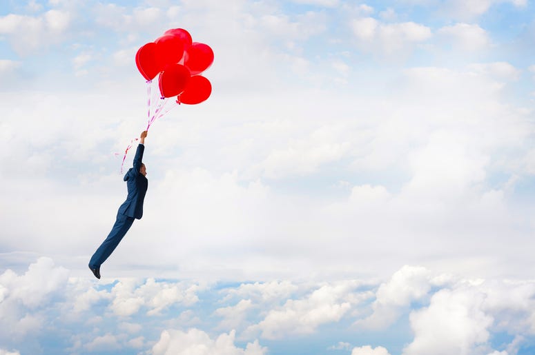 Guy Holding On To Balloons