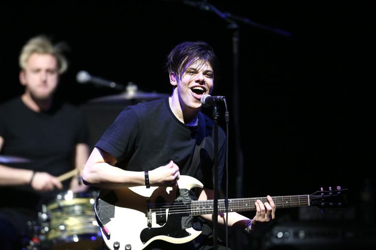 (Rich Polk/ Getty Images) Yunglus smiles as he plays guitar on stage