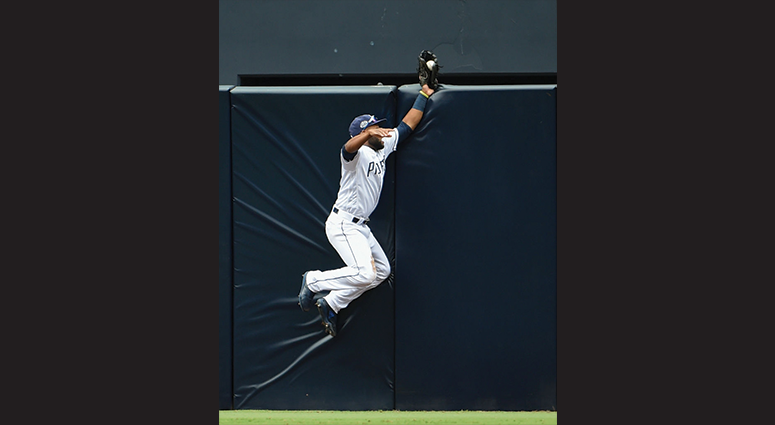 Manuel Margot #7 of the San Diego Padres can't make the catch on a double hit by Brandon Nimmo #9 of the New York Mets during the seventh inning of a baseball game at Petco Park May 8, 2019 in San Diego, California. Margot dropped the ball after slamming