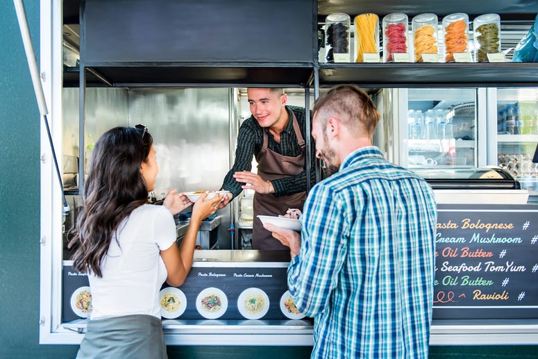 Couple trying some gourmet pasta from a local food truck