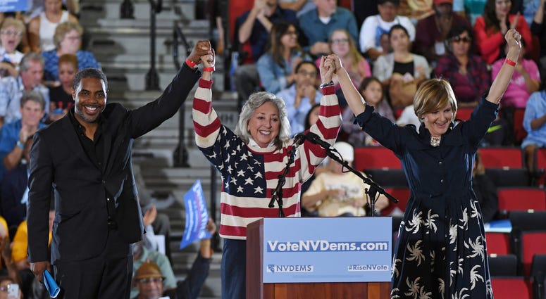 Democratic candidate for Nevada's 4th House District Steven Horsford, U.S. Rep. Dina Titus (D-NV) and Democratic candidate for Nevada's 3rd House District Susie Lee hold hands and raise their arms after speaking during a get-out-the-vote rally