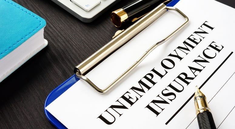 Unemployment insurance form and clipboard on a desk.