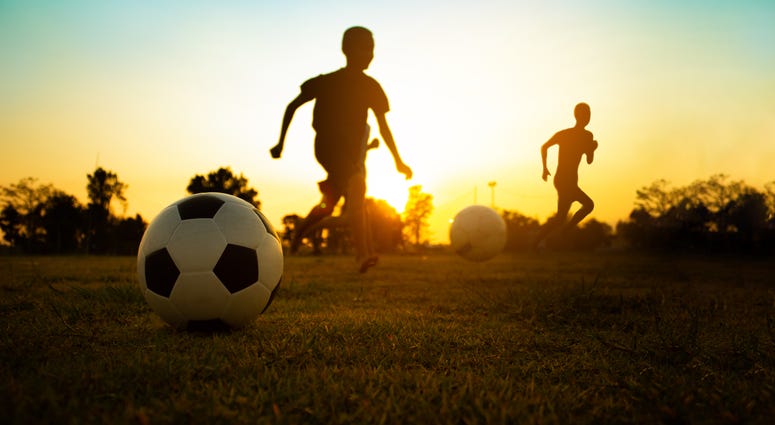 Kids playing soccer in a city park