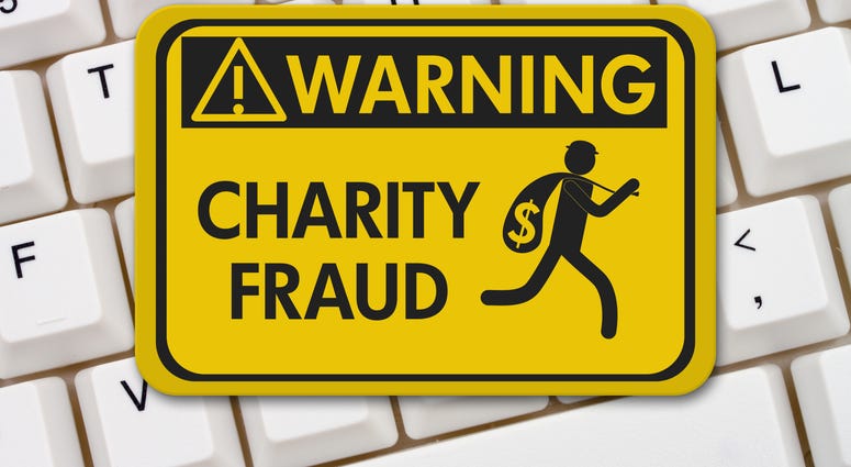 Charity Scam warning sign, A yellow warning sign with text Charity Fraud and theft icon on a keyboard
