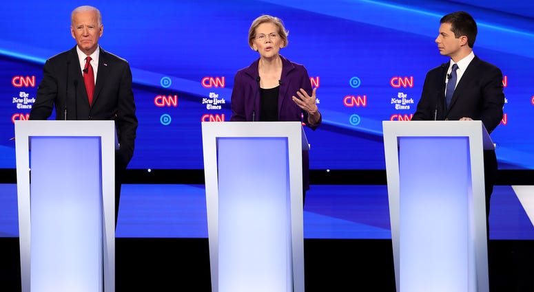 Sen. Elizabeth Warren (D-MA) (C) speaks as former Vice President Joe Biden and South Bend, Indiana Mayor Pete Buttigieg look on during the Democratic Presidential Debate at Otterbein University on October 15, 2019 in Westerville, Ohio.
