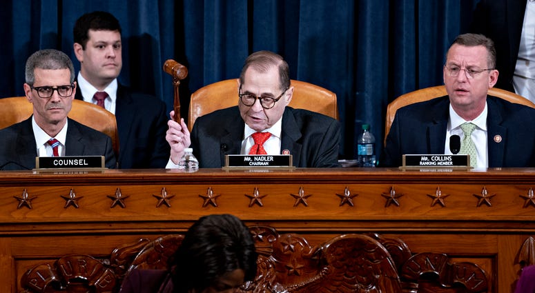 U.S. House Judiciary Committee Chairman Jerry Nadler (D-NY) (C) gavels to an adjournment the committee hearing on the articles of impeachment against President Donald Trump as ranking member Doug Collins (R-GA) (R) looks on at the Longworth House Office