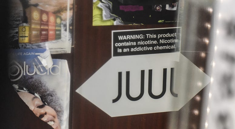 A sign advertising JUUL products is displayed in a store on December 19, 2019 in New York City. Congress raised the legal age to smoke or vape to 21.