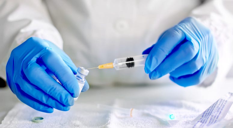 Doctor fills injection syringe with vaccine