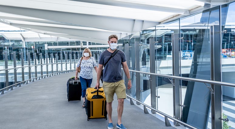 enior woman and adult son wearing face mask at airport in fear of coronavirus and travel ban and international trips cancellations for disease control and prevention of COVID-19 outbreak pandemic.