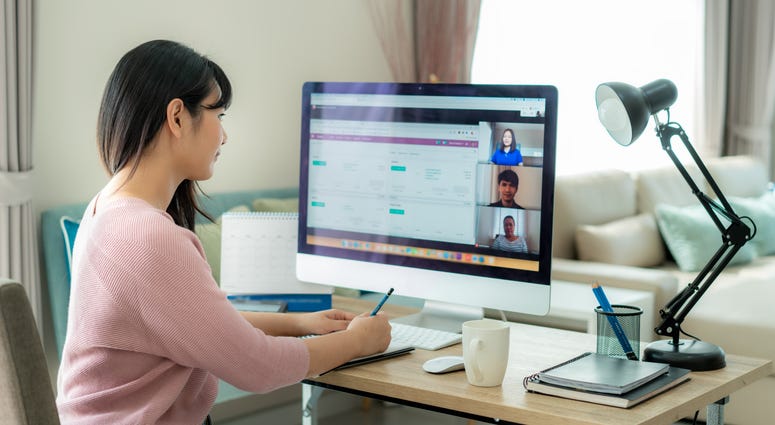 Back view of Asian business woman talking to her colleagues about plan in video conference.