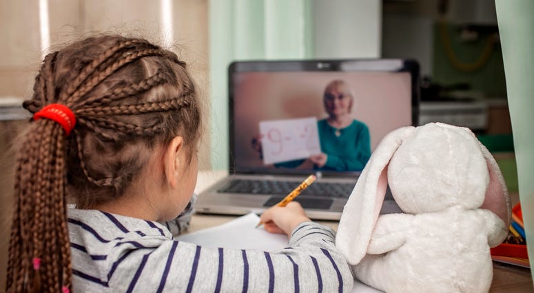 schoolgirl studying math during her online lesson at home, social distance during quarantine, self-isolation, online education concept