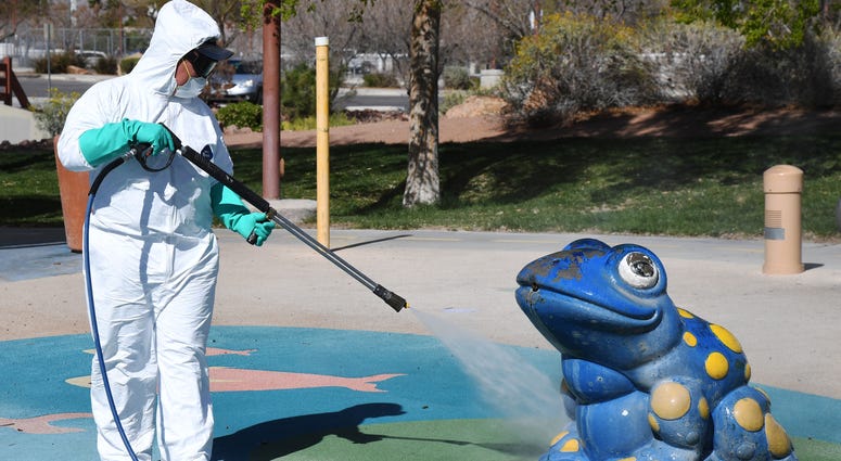 City of Las Vegas operations and maintenance staff worker Denis Connelly pressure washes playground equipment at Centennial Hills Park as part of an effort to keep the city's 70 parks open for the public during the coronavirus pandemic on March 25, 2020 i