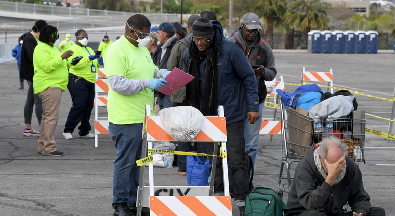 'Help of Southern Nevada' workers check in homeless people as they line up at a temporary homeless shelter set up in a parking lot at Cashman Center on March 28, 2020 in Las Vegas