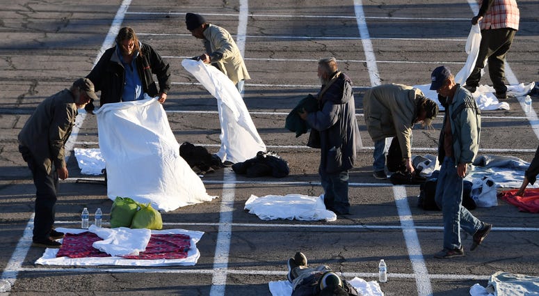 People arrive at a temporary homeless shelter with painted social-distancing boxes in a parking lot at Cashman Center on March 30, 2020 in Las Vegas, Nevada