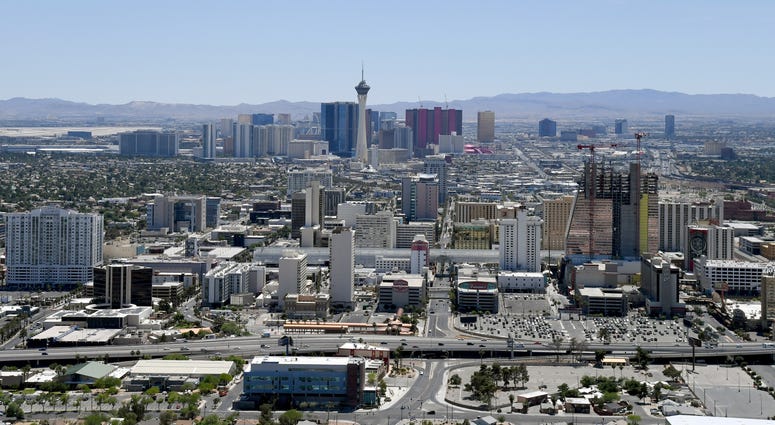 An aerial view shows hotel-casinos and other venues downtown (foreground) and on the Las Vegas Strip
