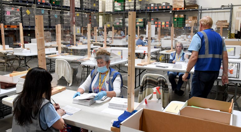 Ann-Marie Gomes (L) and Juanita Thompson count and verify mail ballots at the Clark County Election Department, which is serving as both a primary election ballot drop-off point and an in-person voting center amid the coronavirus pandemic on June 9, 2020