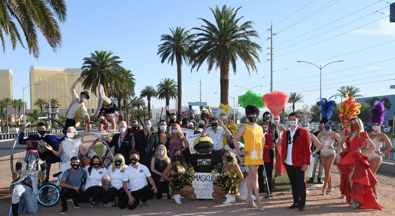 Las Vegas entertainers pose after participating in a fashion show at the Welcome to Fabulous Las Vegas sign on the Las Vegas Strip to kick off the pro-mask wearing campaign