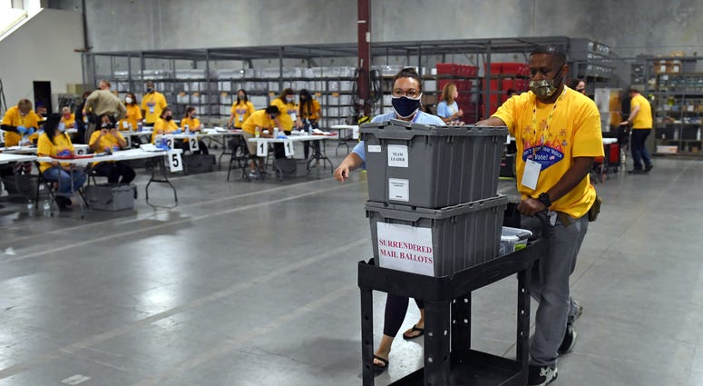 Workers process polling place equipment and materials at the Clark County Election Department after polls closed on November 3, 2020 in North Las Vegas,