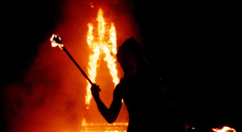 A dancer juggles fire as a 52-foot tall wooden man as it goes up in flames September 2, 2000 during the15th annual Burning Man festival in the Black Rock Desert near Gerlach, Nevada.