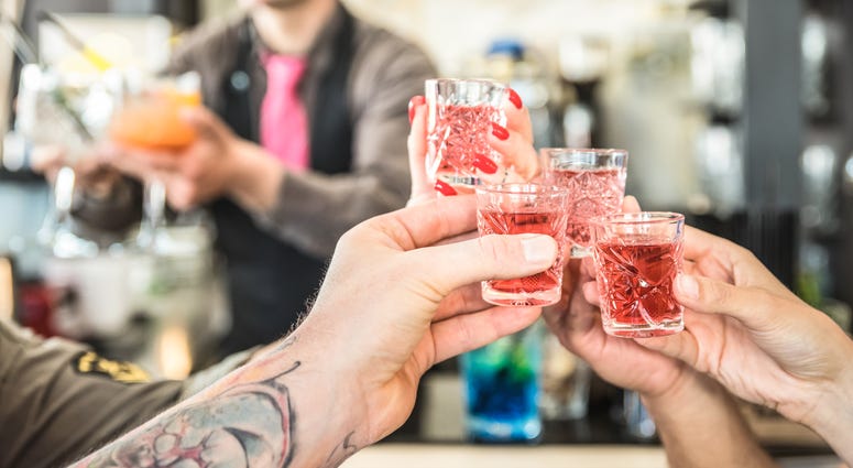 Group of drunk friends toasting cocktails at bar restautant